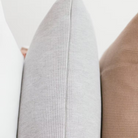  כריות נוי וופל מכותנה אורגנית מסודרות בשורה, ומציגות את צבעי הקולקציה: לבן שלג, אפור מלאנג' וחום שוקו.